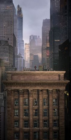 a man standing on top of a tall building in the middle of a large city