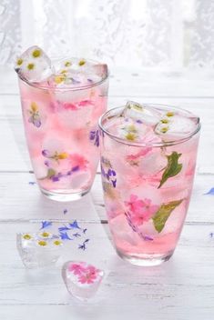 two glasses filled with ice and pink flowers