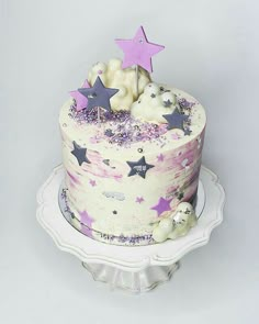 a white cake with purple stars on top