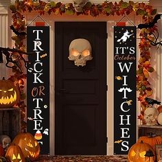 a decorated front door with halloween decorations and pumpkins