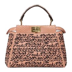 Borsa firmata Fendi, modello Peekaboo, misura mini, realizzata in pelle di pitone rosa, con ricami in rialzo neri con mini paillettes. Dotata di un manico centrale per portata a mano e di una tracolla sottile regolabile e rimovibile. Munita di doppia chiusura a girello fonte e retro, inernamente rivestita in pelle liscia rosa, con presenza di una piccola tasca. Si presenta in ottime condizioni. Bag by Fendi, Peekaboo model, mini size, made of pink python leather, with black raised embroidery with mini sequins. Equipped with a central handle for carrying by hand and a thin adjustable and removable shoulder strap. Equipped with a double twist lock on the front and back, internally lined in smooth pink leather, with a small pocket. It is in excellent condition. Mastrogeppetto Vintage è un neg Fendi Peekaboo Medium, Fendi Peekaboo Mini, Fendi Top, Fendi Casa, Double Twist, Fendi Handbag, Fendi Peekaboo, Vintage Fendi, Fur Accessories