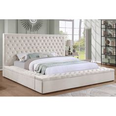 a white bed sitting on top of a wooden floor