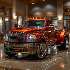 a shiny red truck is parked in a showroom