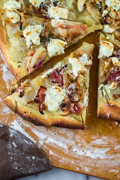 a pizza sitting on top of a wooden cutting board covered in cheese and toppings