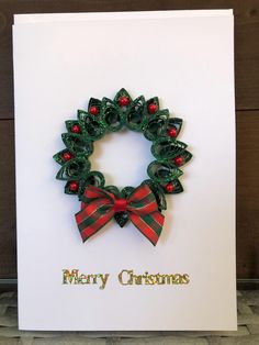 a christmas card with a green wreath and red bow