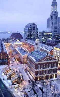 an aerial view of a city at night with snow on the ground and buildings in the background