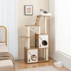 a cat sitting on top of a wooden tower in a bedroom next to a bed