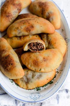 some very tasty looking pastries on a white and blue plate with parsley