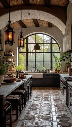 a kitchen with an arched ceiling and tile flooring, along with lots of windows