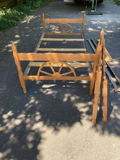 a wooden bed frame with wheels on it