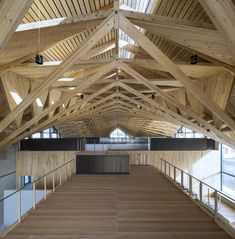 the inside of an empty building with wooden floors and beams on the ceiling is made of wood planks