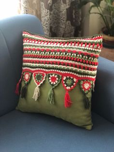 a green pillow sitting on top of a blue chair