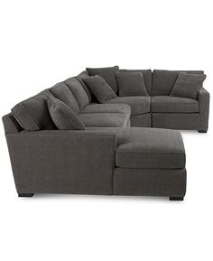 a large sectional couch and ottoman with pillows on the bottom, sitting in front of a white background