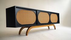 an old fashioned radio sitting on top of a wooden stand in front of a white wall