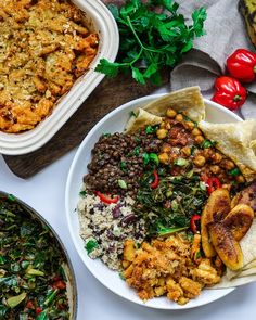 a white plate topped with lots of food next to other plates and bowls filled with food