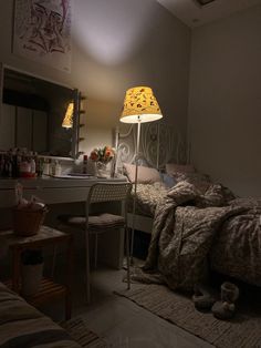 a bed room with a neatly made bed and a chair next to a table lamp