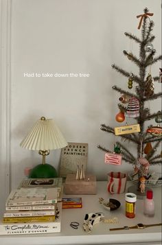 a small christmas tree sitting on top of a table next to books and other items