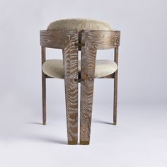 a wooden chair with a sheepskin seat and back rest on a white background,