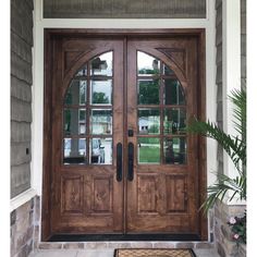 the front door to a house with two double doors and sidelights on either side