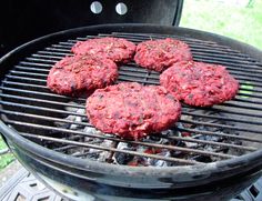 hamburger patties are cooking on an outdoor grill