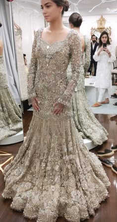 a woman standing in front of a mirror wearing a dress with sequins on it