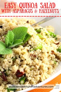 a close up of a bowl of food with green leaves on top and the words easy quinoa salad with asparagus and hazelnuts