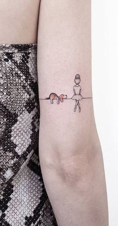 a woman's arm with a small tattoo of two cats and a dog on it