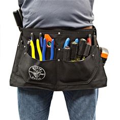 a man holding a tool belt with many different tools in it's pockets,