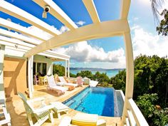 an outdoor swimming pool with lounge chairs overlooking the ocean