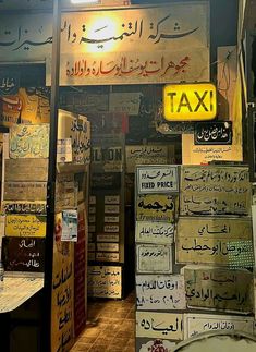 the inside of a taxi shop with many signs on it's walls and in arabic writing