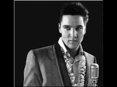 elvis presley singing into a microphone in front of a black background