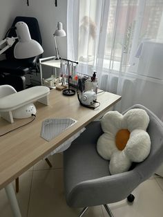 a chair that has a stuffed flower on it in front of a desk with a computer