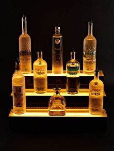 a lighted shelf with bottles of liquor on it