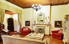 a living room filled with furniture and a fire place in the middle of it's walls