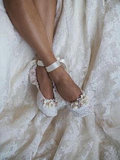 a close up of a person's feet wearing white shoes with flowers on them