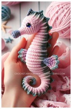 a hand holding a small crocheted sea horse