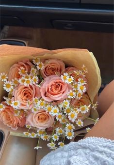 a bouquet of flowers sitting on top of a table next to a person in a car