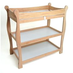 a wooden baby changing table with two shelves on each side and one shelf below it