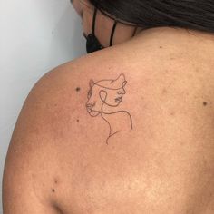 a woman's back with a tattoo on her left shoulder and the outline of a cat