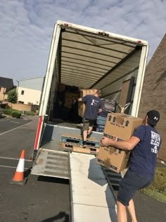 two men unloading boxes from the back of a moving truck