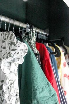 several shirts hanging on a rack in a closet