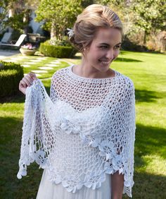 a woman wearing a white crochet shawl with the words spring blooms crocheted shawl pattern