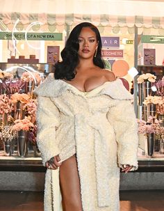 a woman in a fur coat and high heels posing for the camera at a store