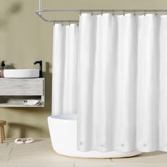 a white shower curtain in a bathroom next to a sink