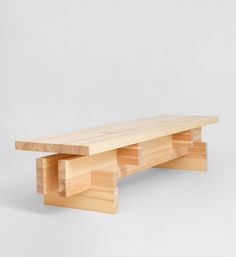 a wooden bench sitting on top of a white wall