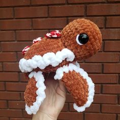 a hand holding up a stuffed animal made to look like an octopus