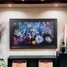 a painting hanging on the wall in a living room with two wicker baskets underneath it