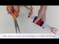 someone is using scissors to cut strips of colored yarn from the bottom of the loom