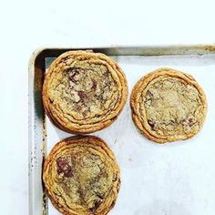 three cookies sitting on top of a baking pan