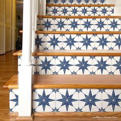 blue and white tiled stairs leading up to the second floor in a home with wood floors